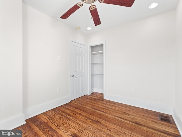 unfurnished bedroom featuring a closet, ceiling fan, and dark hardwood / wood-style flooring