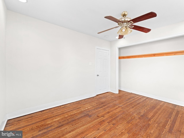 unfurnished bedroom with ceiling fan, a closet, and hardwood / wood-style flooring