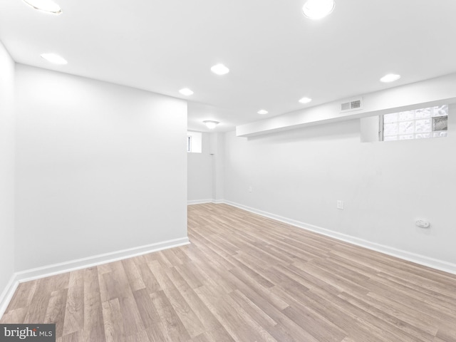 basement with light hardwood / wood-style floors and a healthy amount of sunlight