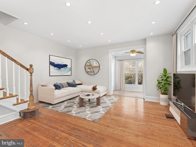 living room with light hardwood / wood-style flooring and ceiling fan