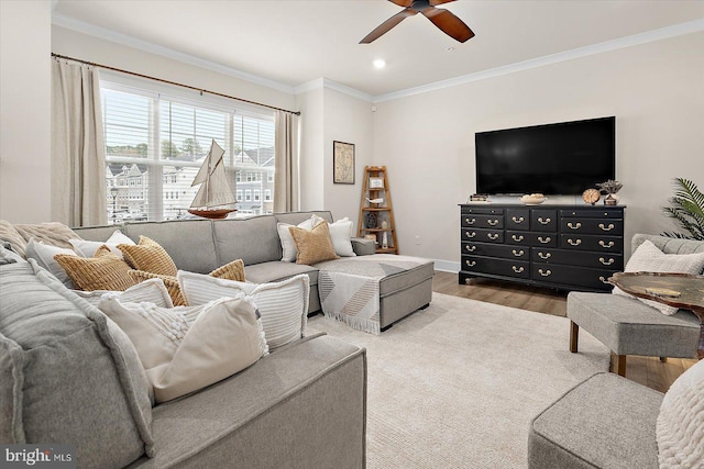 living room with light wood-type flooring, ceiling fan, and ornamental molding