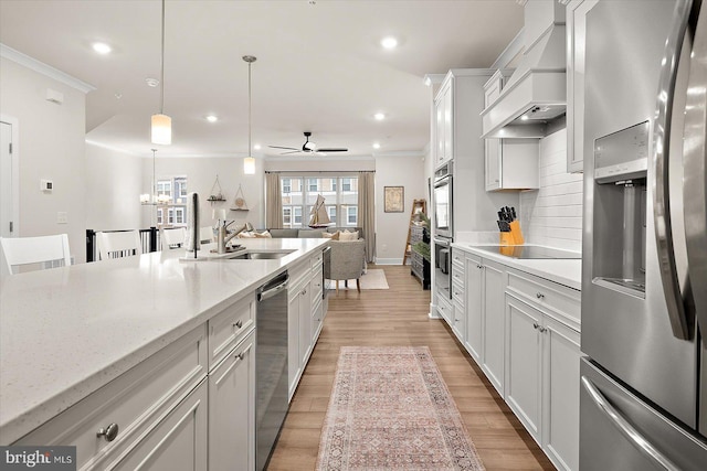 kitchen with stainless steel appliances, ceiling fan, sink, decorative light fixtures, and white cabinetry