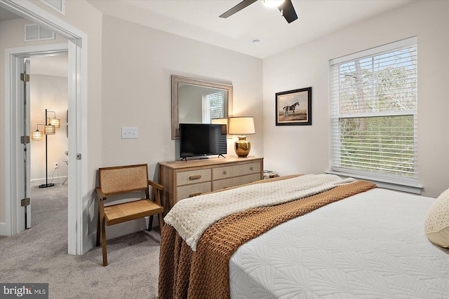 bedroom with multiple windows, light carpet, and ceiling fan