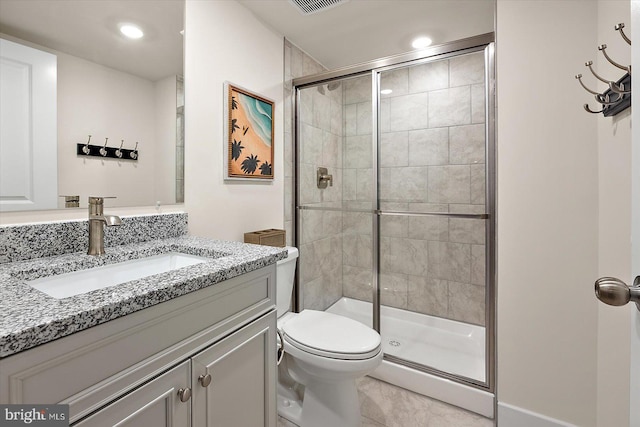 bathroom with tile patterned flooring, vanity, an enclosed shower, and toilet