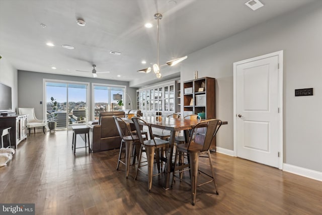 dining room with ceiling fan and dark wood-type flooring