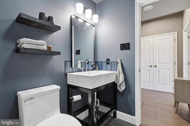 bathroom featuring vanity, wood-type flooring, and toilet