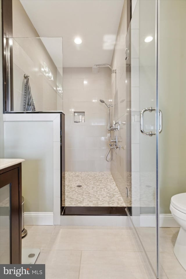 bathroom with tile patterned flooring, vanity, toilet, and an enclosed shower