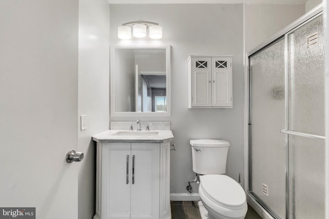 bathroom featuring hardwood / wood-style floors, vanity, an enclosed shower, and toilet