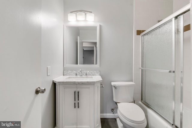 full bathroom featuring vanity, toilet, and bath / shower combo with glass door