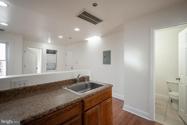 kitchen with electric panel, hardwood / wood-style flooring, and sink