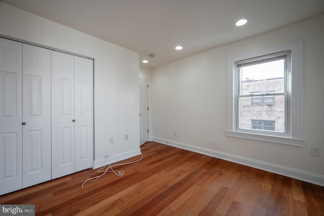 unfurnished bedroom with a closet and hardwood / wood-style floors