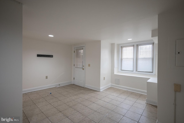 spare room featuring electric panel and light tile patterned flooring