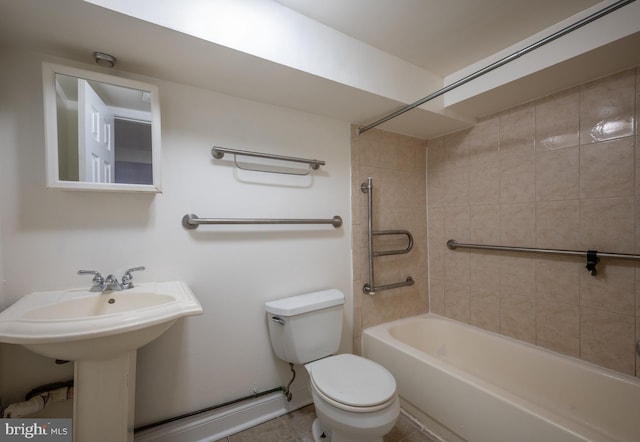 bathroom with tile patterned floors, tiled shower / bath combo, and toilet