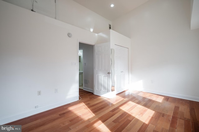 spare room featuring hardwood / wood-style flooring and a high ceiling