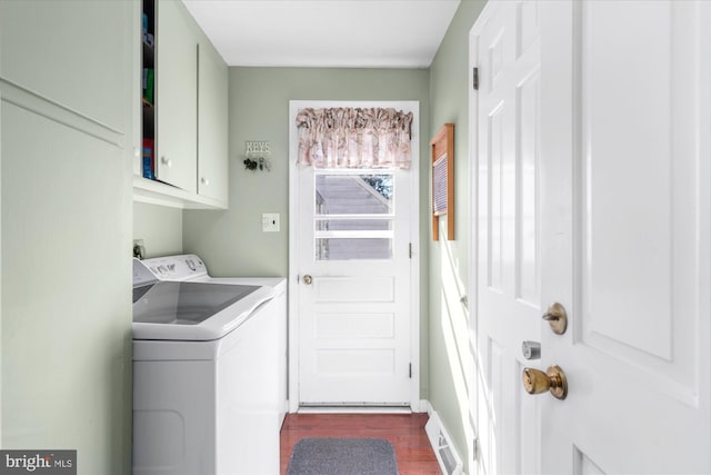 laundry area with dark wood-style floors, independent washer and dryer, and cabinet space