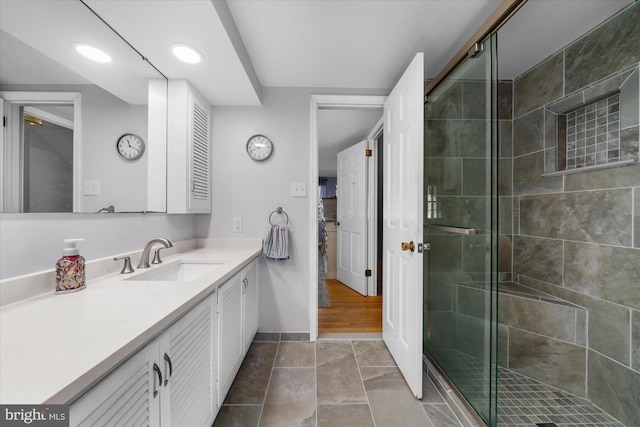 full bath with a shower stall, baseboards, tile patterned flooring, and vanity