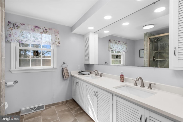 bathroom with double vanity, a sink, visible vents, and a shower stall