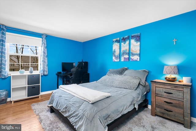 bedroom featuring wood finished floors and baseboards