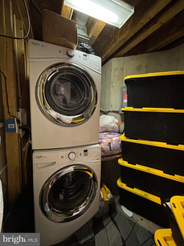 clothes washing area featuring stacked washer and dryer