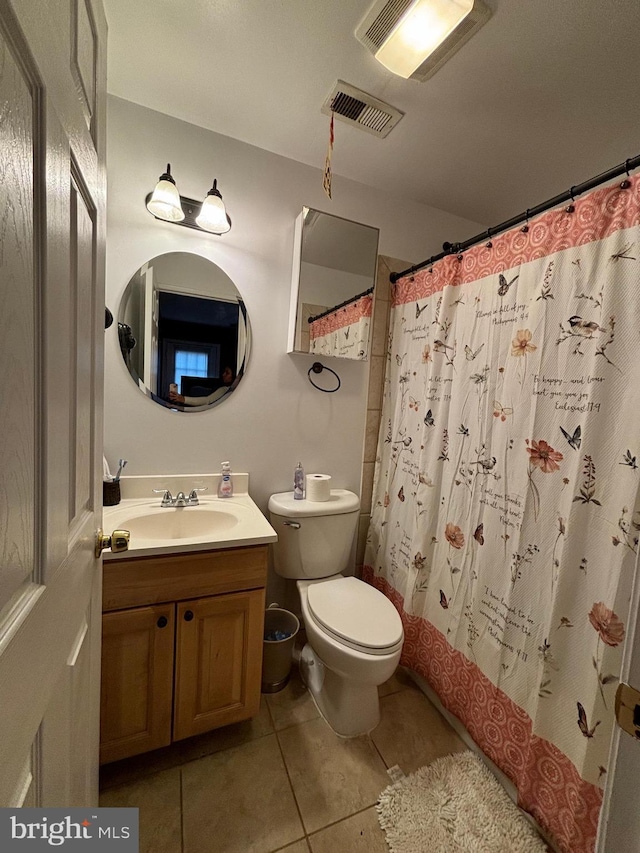 bathroom featuring a shower with shower curtain, vanity, tile patterned floors, and toilet