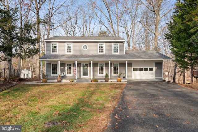 view of front facade with a porch, a garage, and a front lawn