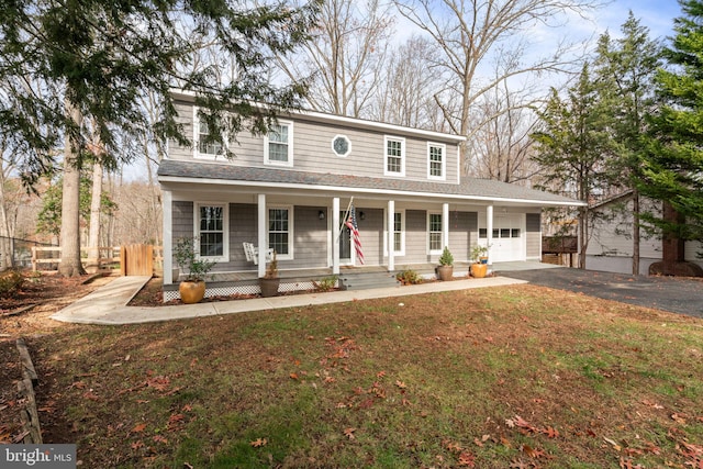 view of front of property with a porch, a garage, an outdoor structure, and a front lawn