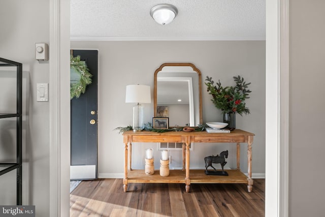 foyer entrance featuring a textured ceiling, hardwood / wood-style flooring, and crown molding