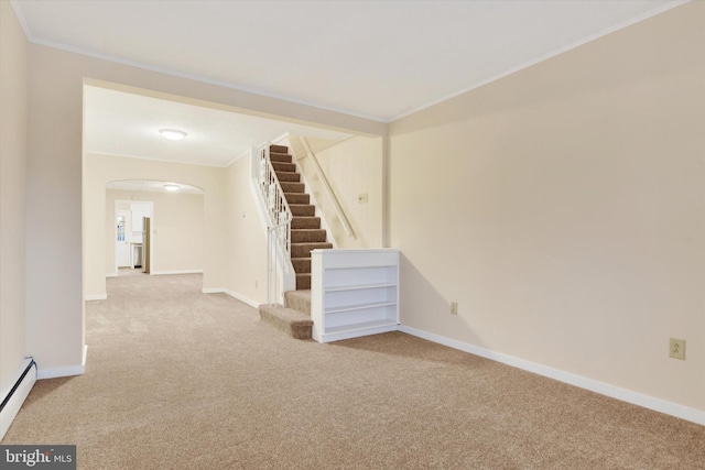 spare room featuring light colored carpet, baseboard heating, and ornamental molding