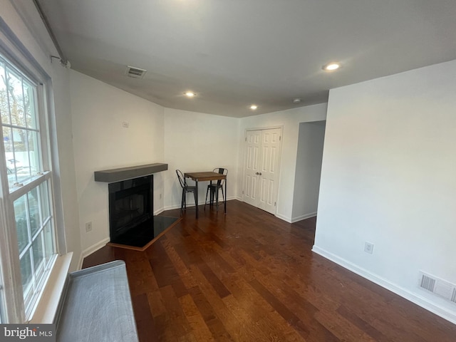 unfurnished living room with dark wood-type flooring