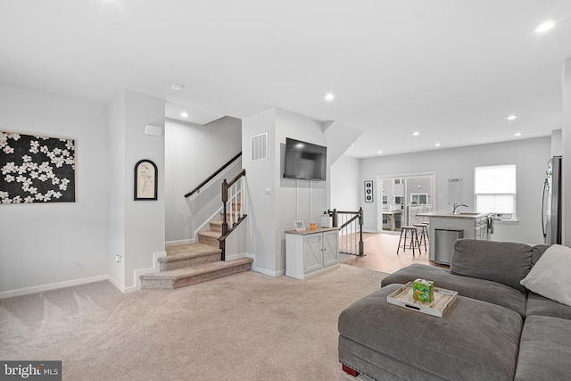 carpeted living room with sink