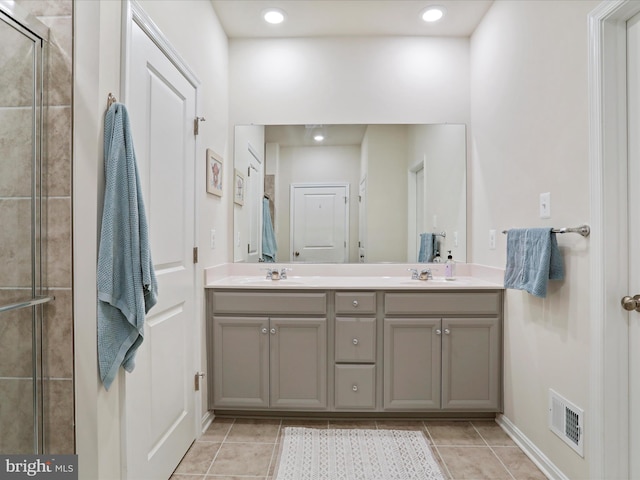 bathroom featuring tile patterned floors, a shower with door, and vanity