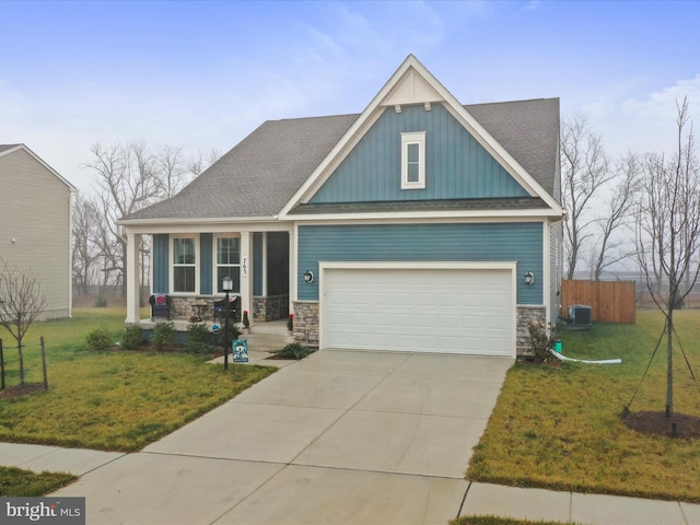 craftsman inspired home featuring cooling unit, a front lawn, and a garage