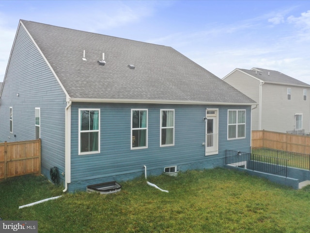 rear view of house featuring a lawn