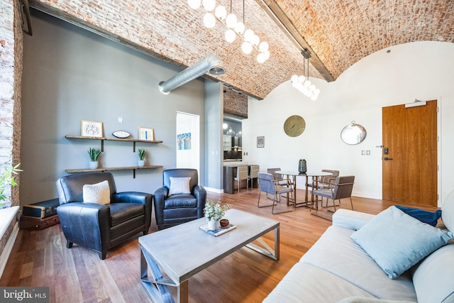 living room featuring wood-type flooring, vaulted ceiling, and brick ceiling