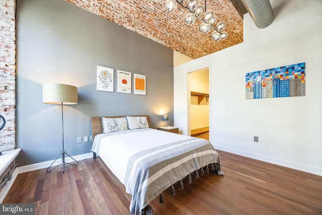 bedroom featuring brick ceiling and hardwood / wood-style floors