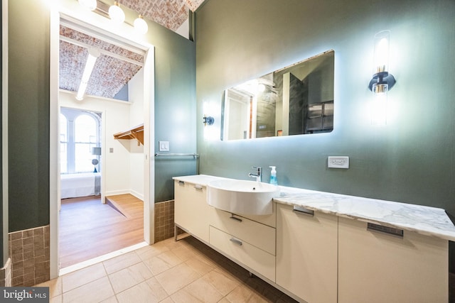 bathroom with beam ceiling, vanity, and tile patterned floors