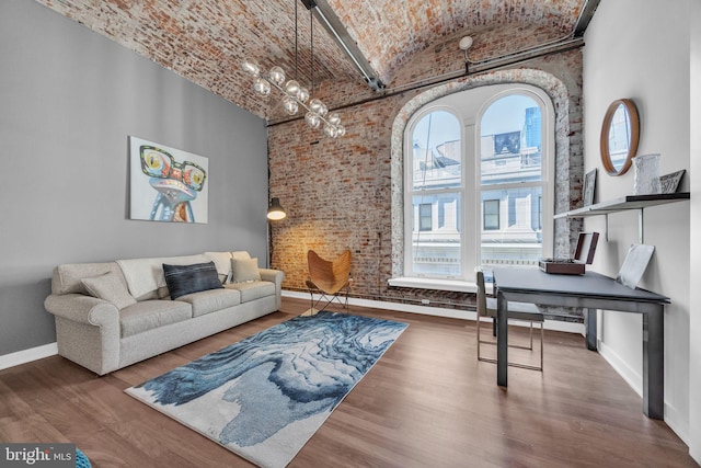 living room with brick wall, vaulted ceiling, hardwood / wood-style flooring, and brick ceiling