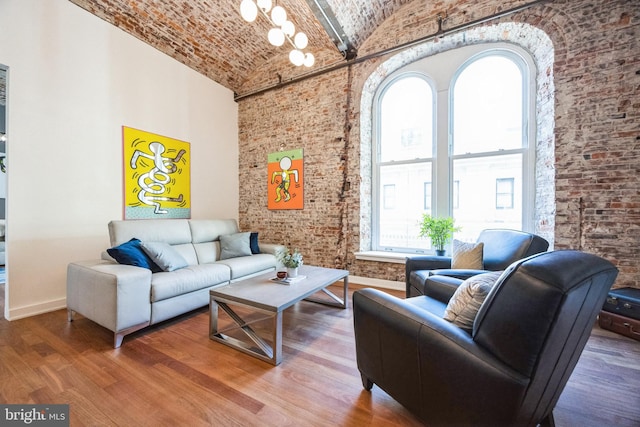 living room featuring brick wall, high vaulted ceiling, brick ceiling, and hardwood / wood-style floors