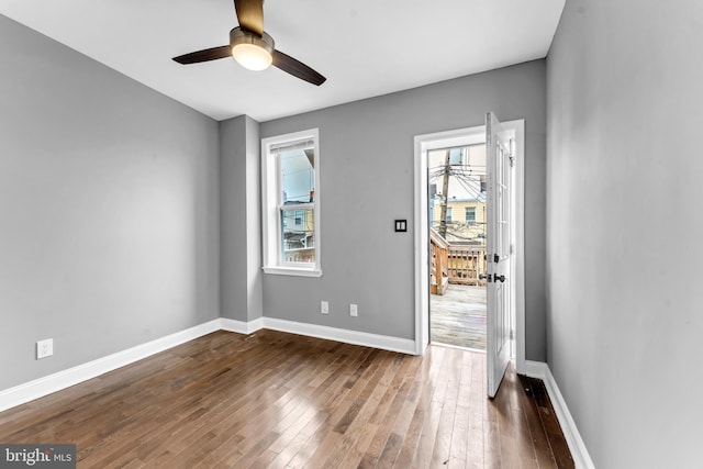 unfurnished room featuring ceiling fan and dark wood-type flooring