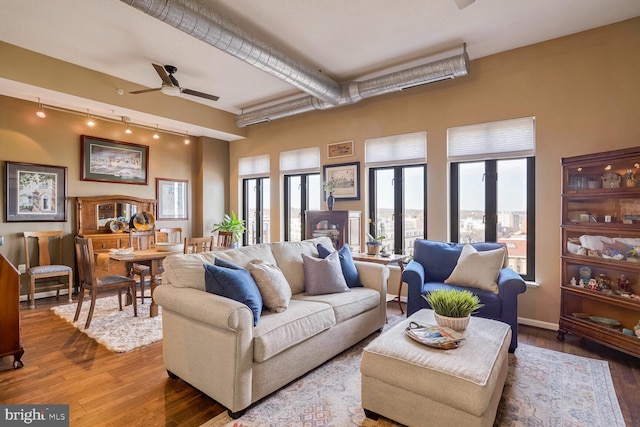 living room featuring ceiling fan, a healthy amount of sunlight, and wood-type flooring