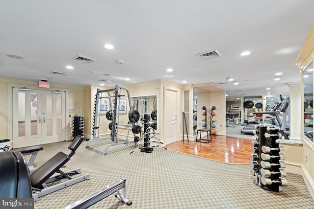 workout area featuring ornamental molding, french doors, and light hardwood / wood-style flooring