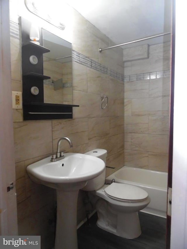 bathroom featuring tiled shower / bath combo and toilet