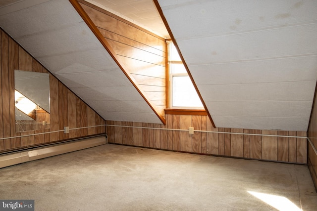 additional living space with carpet floors, baseboard heating, lofted ceiling, and wood walls