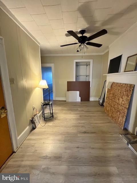 interior space with crown molding, hardwood / wood-style floors, and ceiling fan