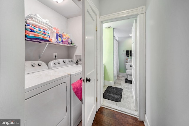 washroom featuring washing machine and dryer and hardwood / wood-style flooring