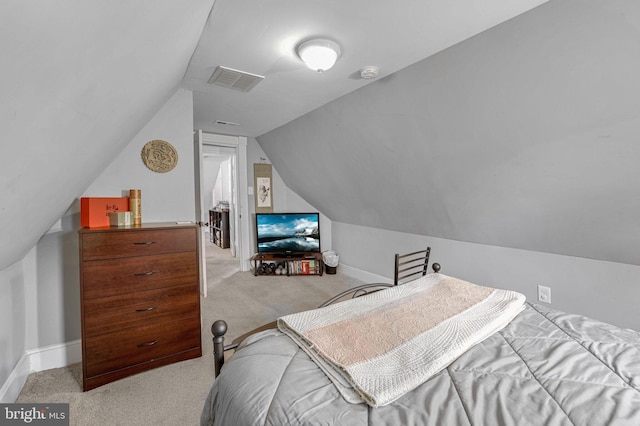 bedroom featuring light colored carpet and vaulted ceiling