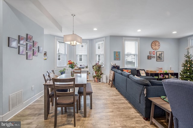 dining space featuring light hardwood / wood-style flooring and an inviting chandelier