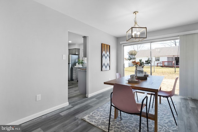 dining area featuring dark hardwood / wood-style floors and a notable chandelier