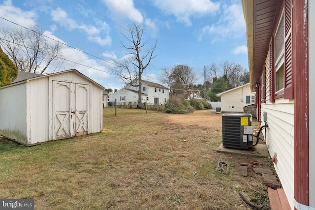 view of yard featuring central AC unit and a storage shed