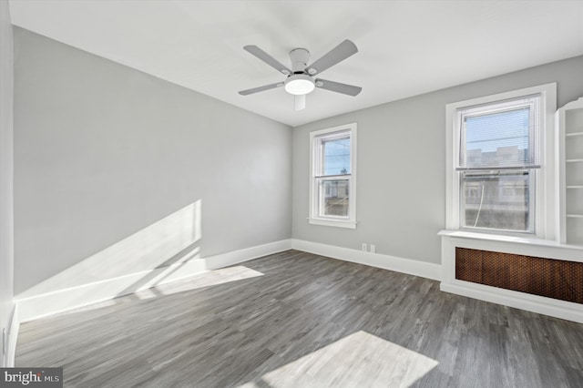 spare room featuring ceiling fan and dark wood-type flooring